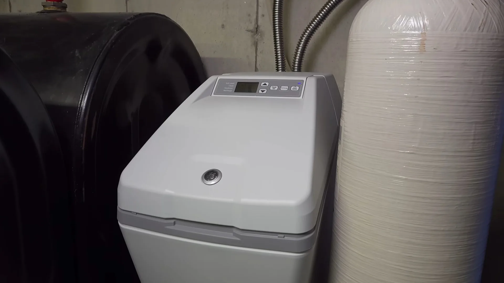 Gray water softener with a digital display beside a black brine tank and a tall resin tank